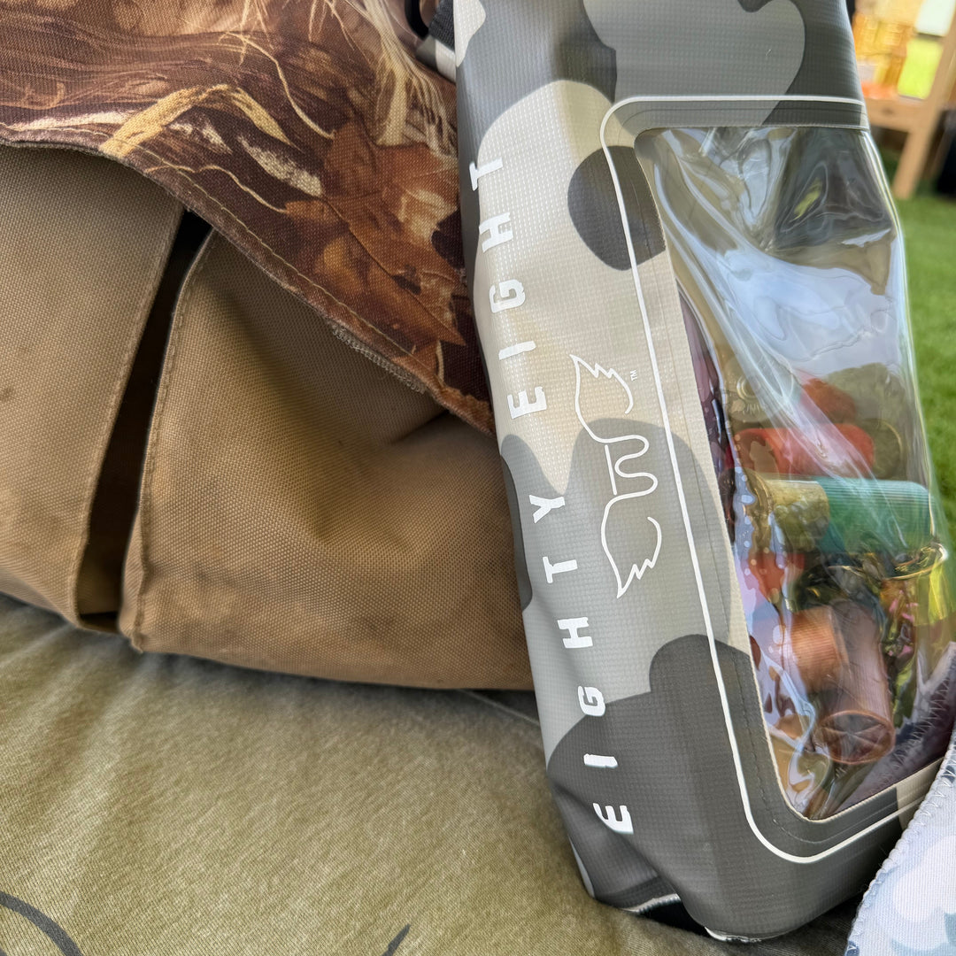 A gray and white waterproof bag with a clear window and the text &