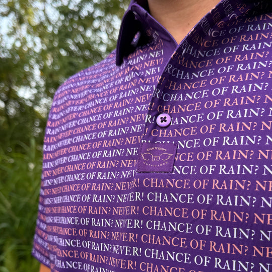A close-up of a person wearing a purple short-sleeve polo shirt with an all-over repeating text pattern of &