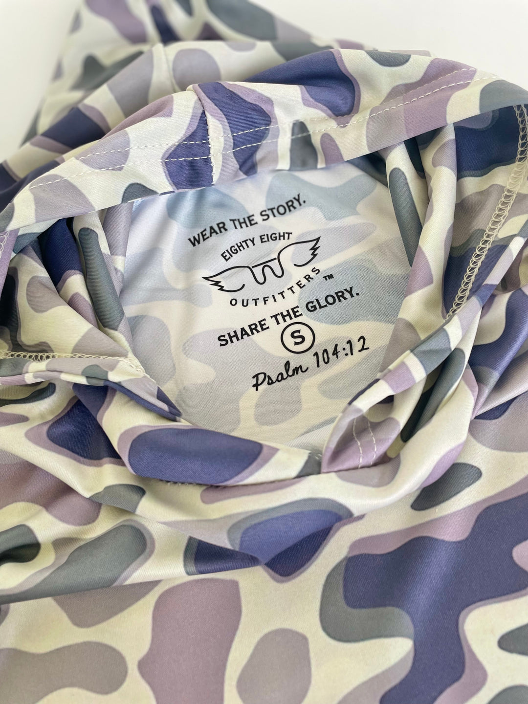 Camouflage-patterned product with branding and text on a white background