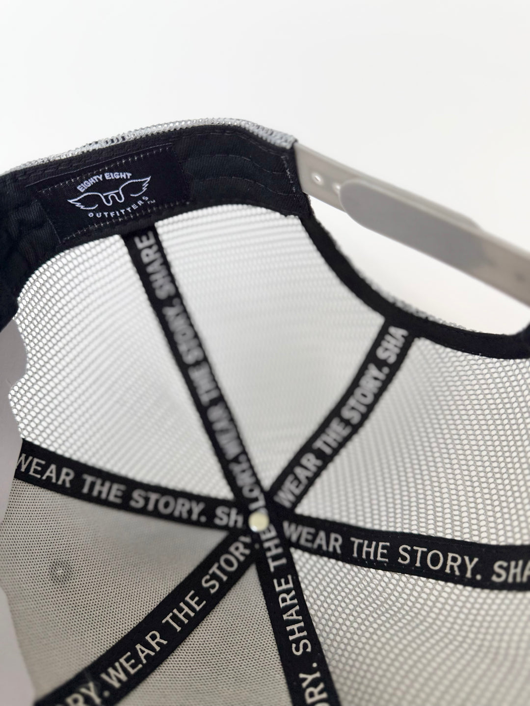 Close-up of a cap with mesh back and branding on a white background