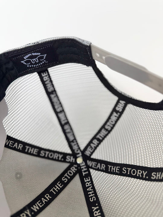 Close-up of a cap with mesh back and branding on a white background