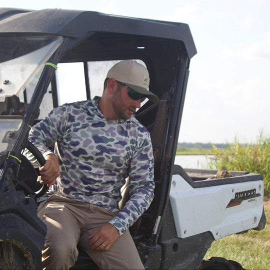 Man standing next to a utility terrain vehicle (UTV) in an outdoor setting.