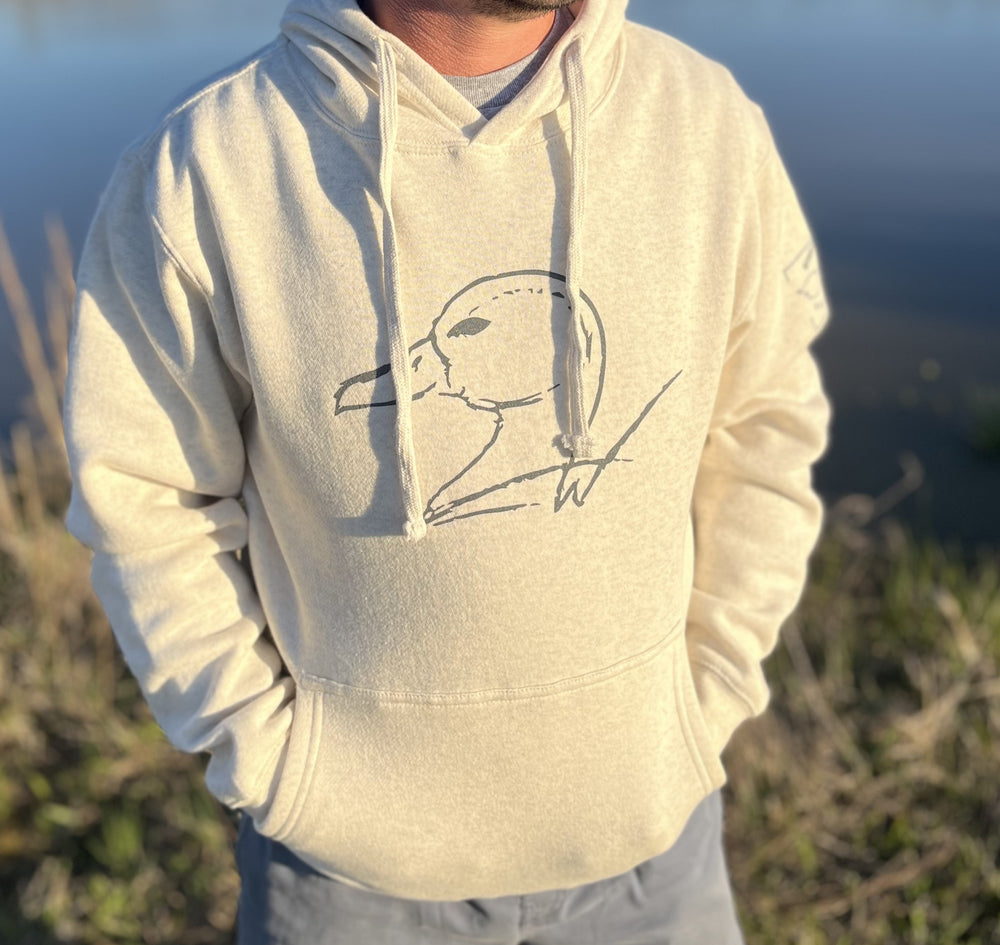 Person wearing a light-colored hoodie with a graphic design outdoors