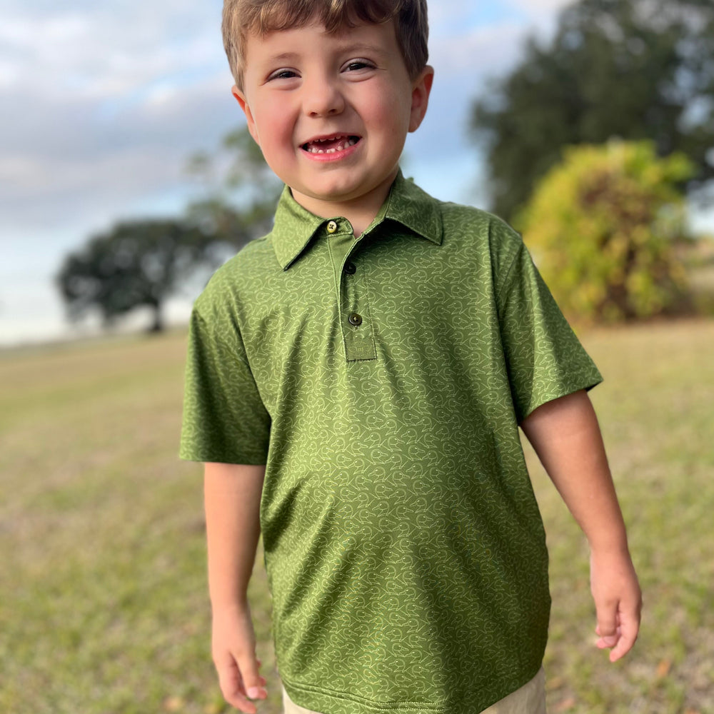 toddler boy in green polo with duck pattern