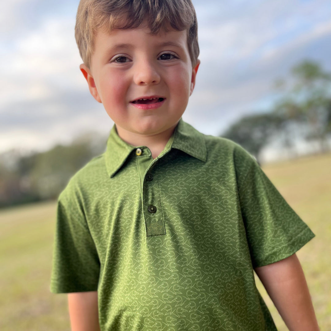 toddler boy in green polo with duck pattern