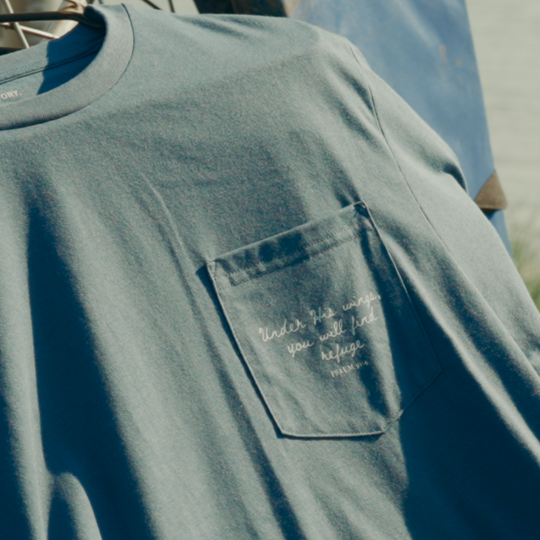 Blue t-shirt with a pocket detail on a boat