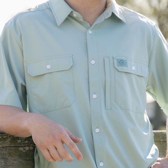 Light green short-sleeve shirt worn by a person, with a blurred natural background