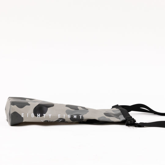 Camouflage-patterned product with a black strap on a white background