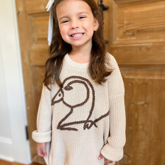 youth girl wearing khaki crochet sweater with brown duck logo